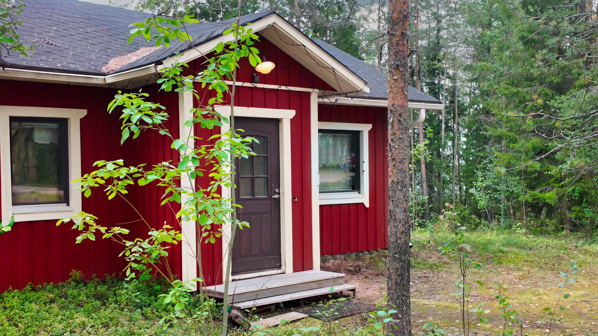 Punainen mökki metsässä maaseutumatkailuun